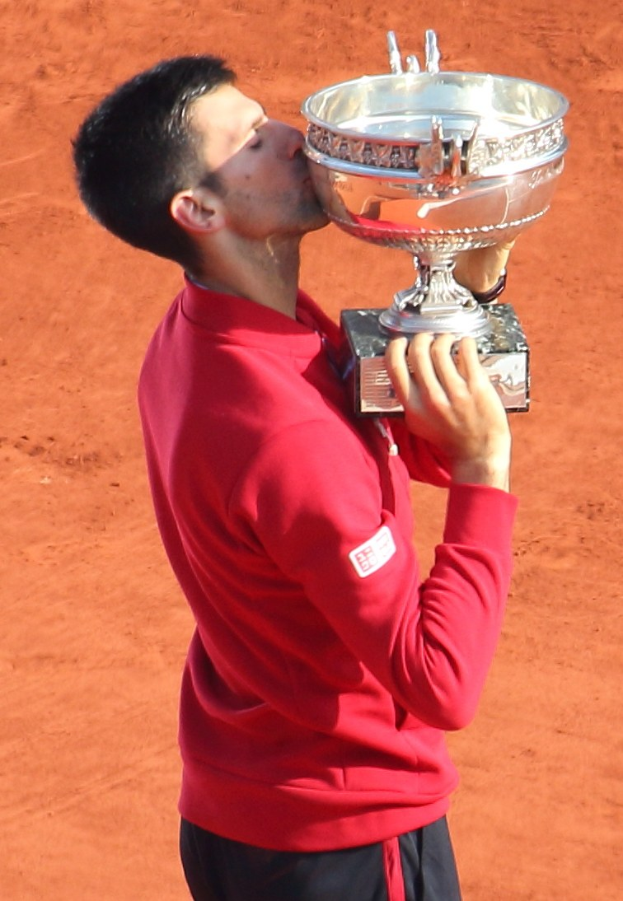 Novak Djokovic hält den French Open-Pokal nach Sieg gegen Rafael Nadal in der Herren-Einzel-Finalrunde, küsst den Pokal mit einem triumphierenden Gesichtsausdruck.