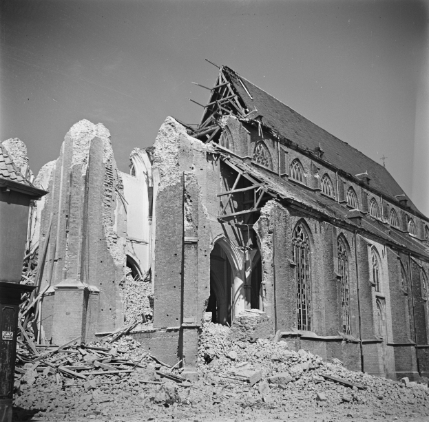 Schwarzes und weißes Foto einer zerstörten alten Kirche mit gebrochenen Wänden, Schutt und sichtbarem Himmel darüber.