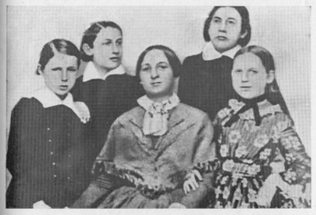 Schwarzes und weißes Foto einer Gruppe von Frauen, mit einer sitzend in der Mitte, verbunden mit dem Text "Die Frauenwahlrechtsbewegung."