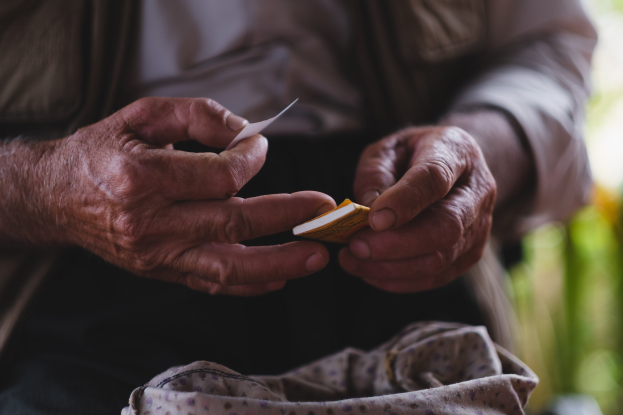 Alter Mann hält ein Blatt Papier und sieht besorgt aus mit unscharfem Hintergrund.