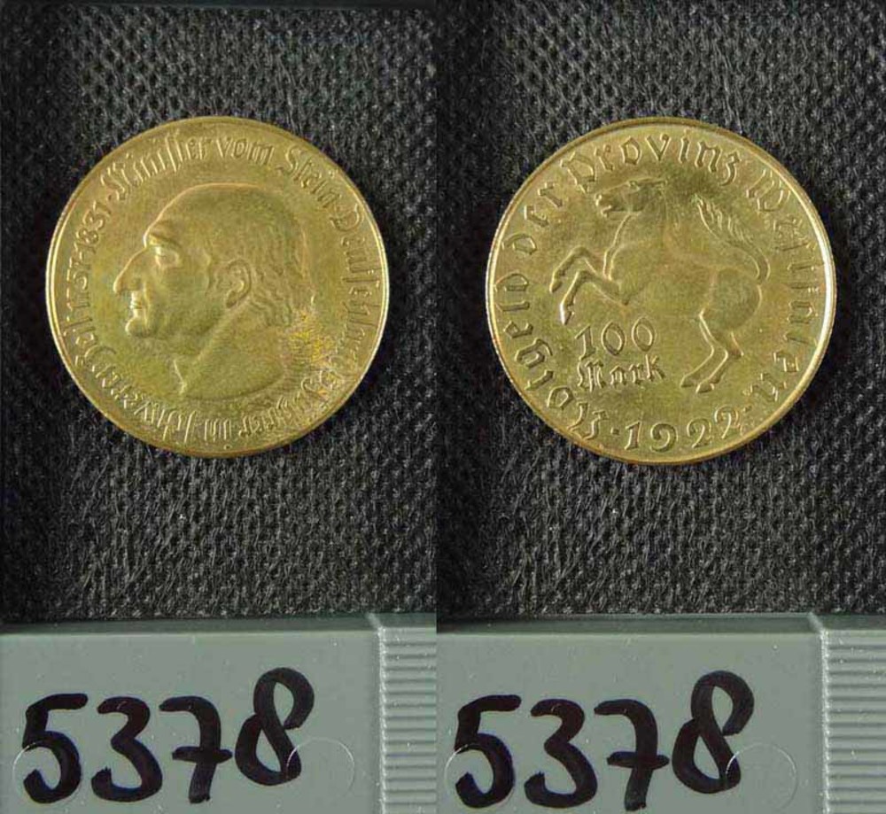 Zwei Goldmünzen aus Deutschland im Jahr 1922, jeweils mit einer Denomination von 100 Mark, liegen auf einer schwarzen Oberfläche mit Zahlen unten.