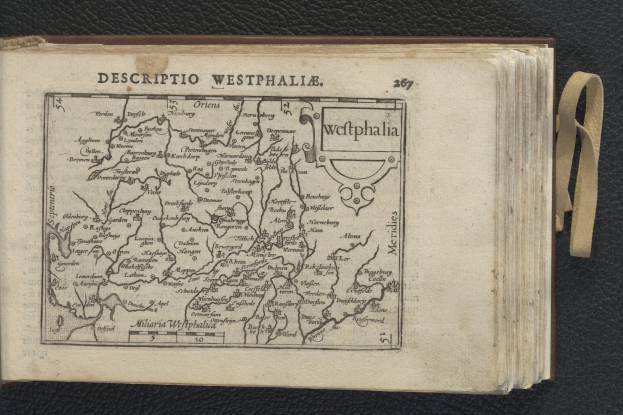 Offenes Buch mit einer detaillierten Karte von Westfalen auf einer schwarzen Oberfläche, das geografische Merkmale zeigt.