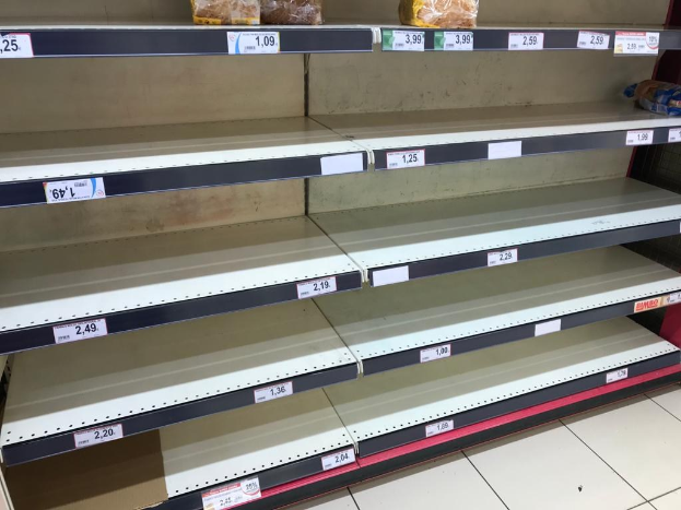 Leere Supermarktregale ohne Lebensmittel, in einer Reihe aufgereiht, zeigen den Boden darunter.