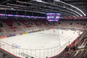 Hockey-Spiel in einer großen Arena zwischen den St. Louis Blues und Detroit Red Wings, mit Zuschauern auf Sitzen und Stehplätzen.