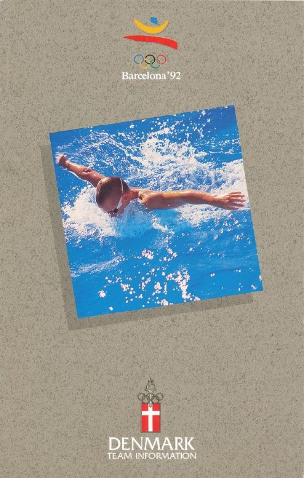 Ein Plakat eines Schwimmers in einem blauen Anzug mit ausgestreckten Armen vor einem hellblauen Himmel mit weißen Wolken, mit dem Logo der Olympischen Spiele Barcelona 1992 und dem Text "Danish Team Information".