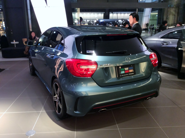 Ein Mercedes-Benz A-Klasse Hatchback mit glänzender schwarzer Lackierung und Chromakzenten, das auf der IAA in Frankfurt ausgestellt wird, umgeben von Menschen.